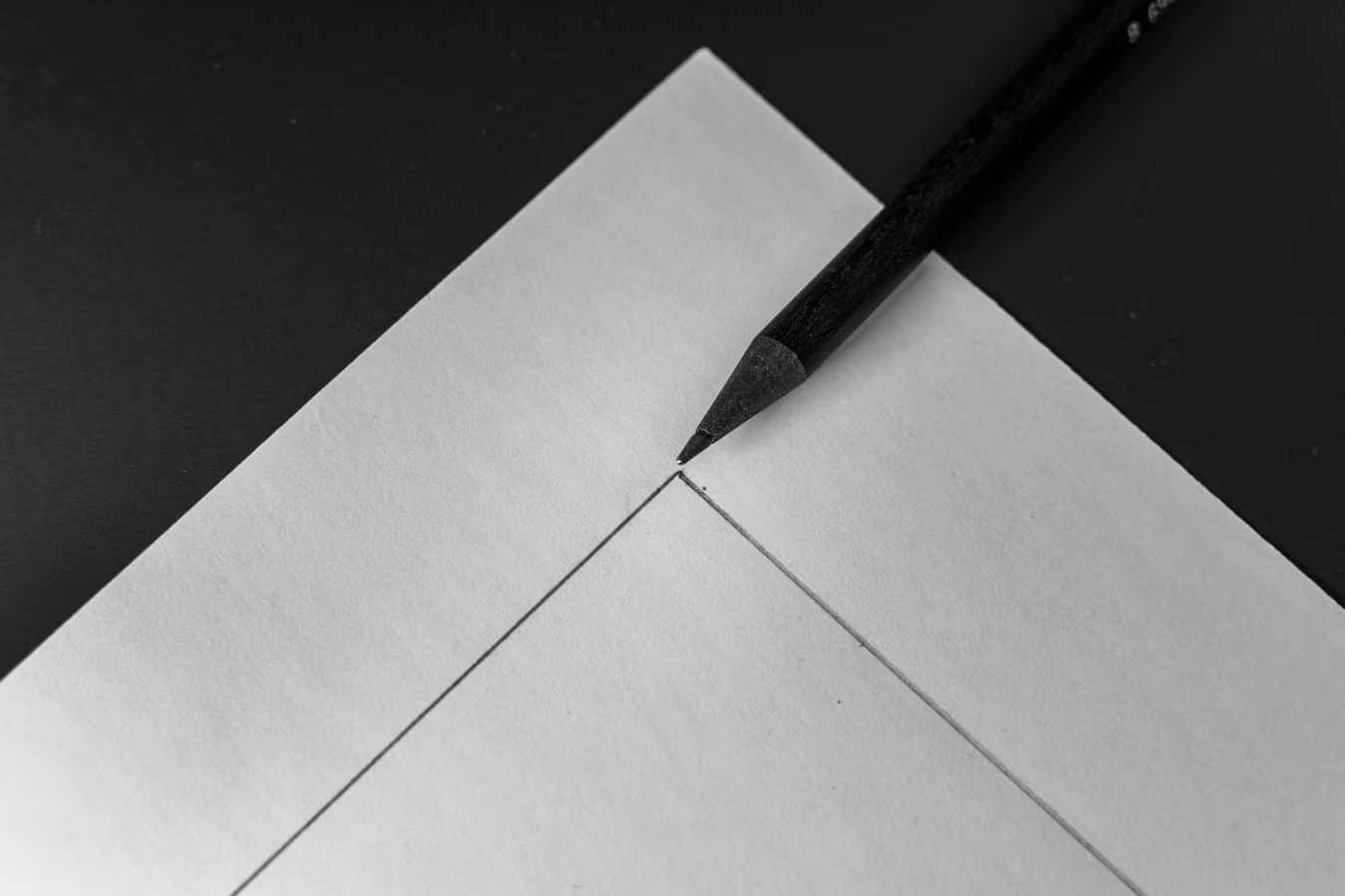 Close-up van potloodpunt die raakpunt van twee lijnen op papier aanwijst, benadrukt nauwkeurigheid tekenen ontwerpen neem contact op